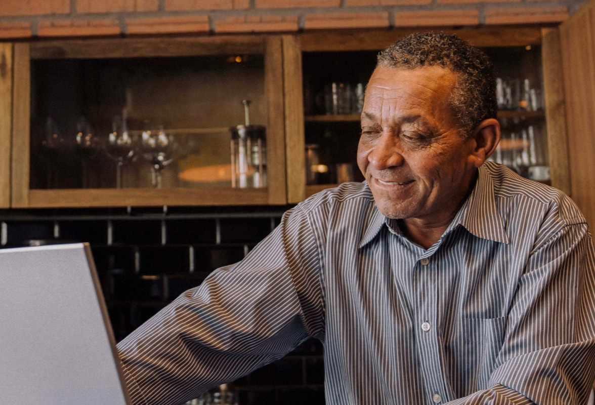 elderly man smiling on laptop