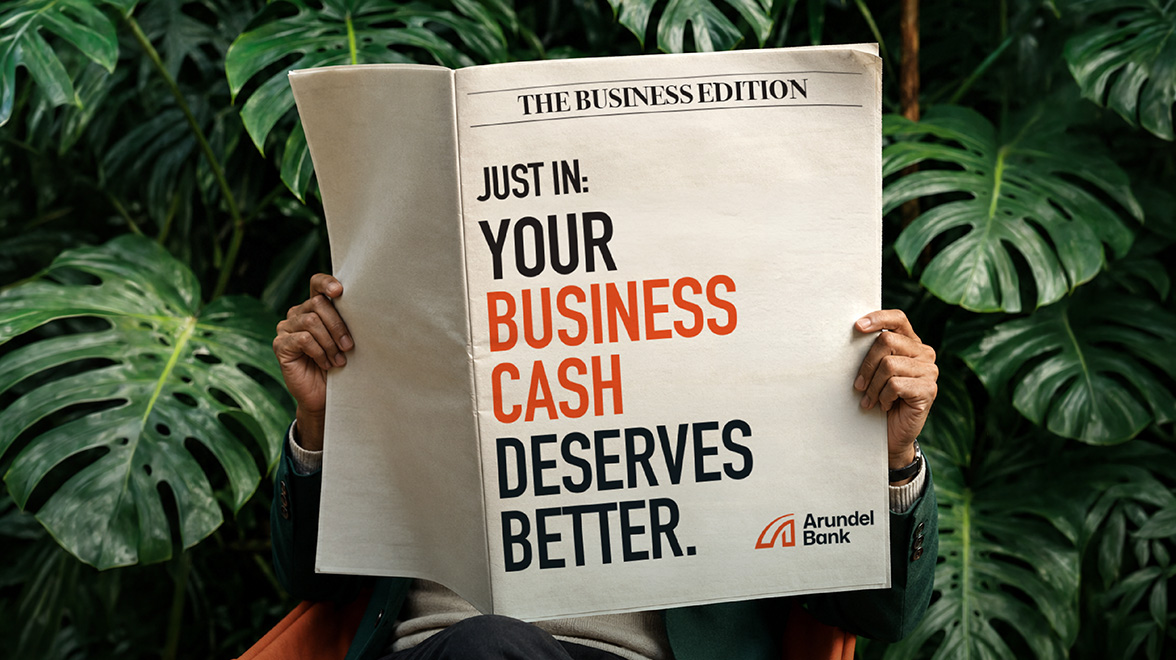 man holding newspaper with bold headline 